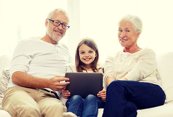 Image showing smiling family with tablet pc at home