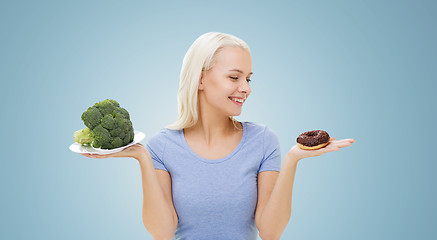 Image showing smiling woman with broccoli and donut