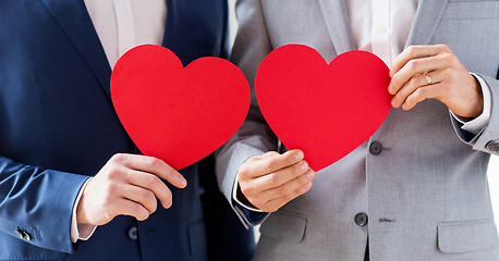 Image showing close up of male gay couple holding red hearts