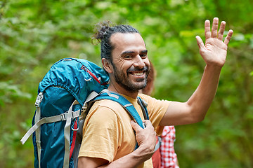 Image showing group of smiling friends with backpacks hiking