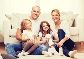 Image showing parents and two girls sitting on floor at home