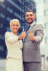 Image showing smiling businessmen showing thumbs up