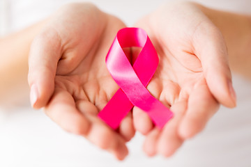 Image showing close up of hands and pink cancer awareness ribbon