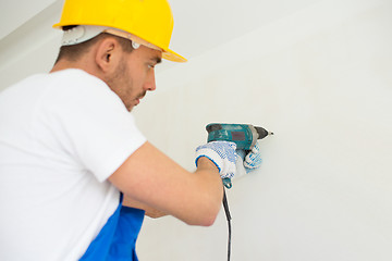 Image showing close up of builders with drill perforating wall