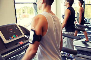 Image showing smiling men exercising on treadmill in gym