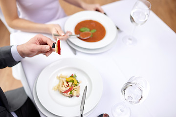 Image showing close up of couple eating appetizers at restaurant