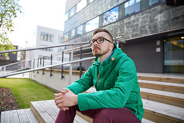 Image showing happy young hipster man sitting on stairs in city