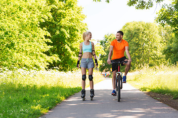 Image showing happy couple with roller skates and bicycle riding