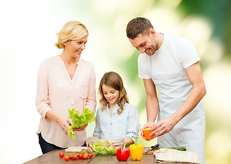 Image showing happy family cooking vegetable salad for dinner