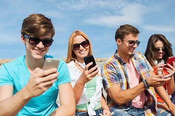 Image showing group of happy friends with smartphones outdoors