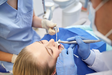 Image showing close up of dentist treating female patient teeth