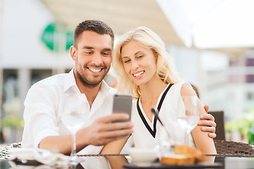 Image showing happy couple taking selfie with smatphone at cafe