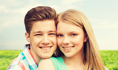 Image showing smiling couple hugging over natural background