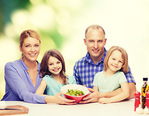 Image showing happy family with two kids with salad at home