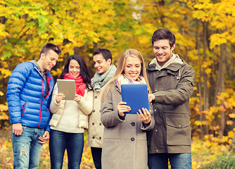 Image showing group of smiling friends with tablets in park