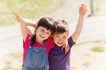 Image showing two happy kids hugging outdoors
