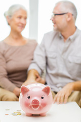 Image showing close up of couple with coins and piggy bank