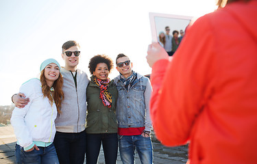 Image showing happy teenage friends with tablet pc photographing