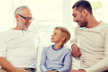 Image showing smiling family sitting on couch home