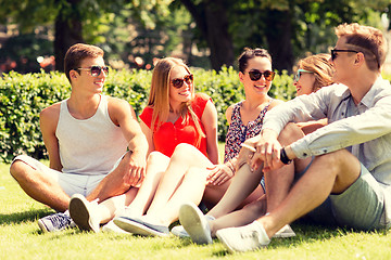 Image showing group of smiling friends outdoors sitting on grass