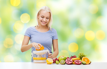 Image showing smiling woman squeezing fruit juice