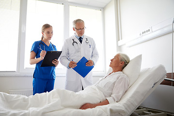 Image showing doctor and nurse visiting senior woman at hospital