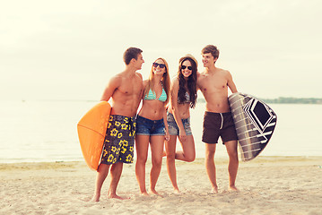 Image showing smiling friends in sunglasses with surfs on beach