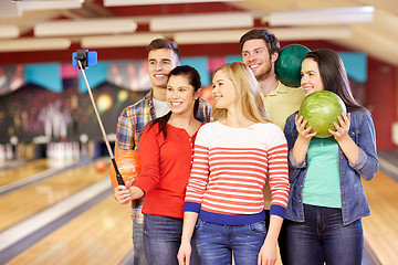 Image showing happy friends taking selfie in bowling club