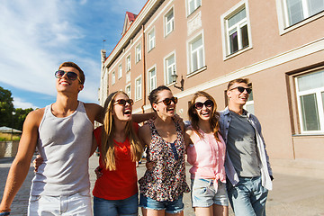 Image showing group of smiling friends walking in city