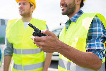 Image showing close up of builders in vests with walkie talkie