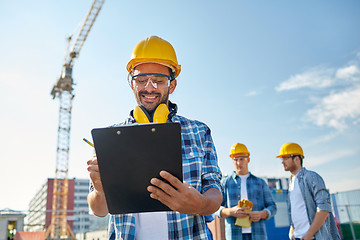 Image showing builder in hardhat with clipboard at construction