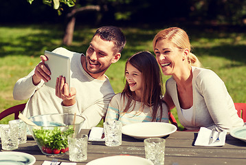 Image showing happy family with tablet pc at table in garden