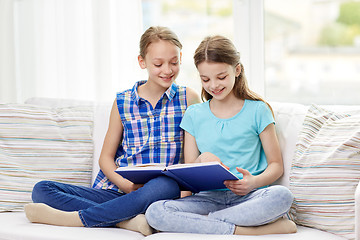 Image showing two happy girls reading book at home