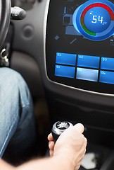 Image showing hand on car gearshift and screen with volume level