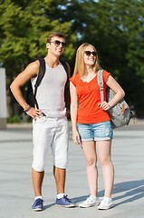 Image showing smiling couple with backpacks in city