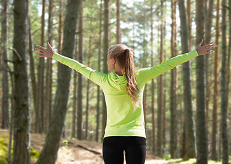 Image showing happy woman in sport clothes raising hands