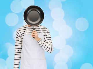 Image showing man or cook in apron hiding face behind frying pan