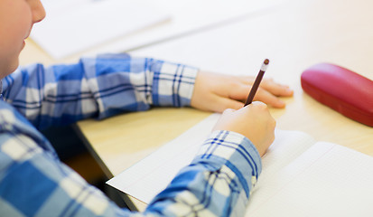 Image showing close up of schoolboy writing test at school
