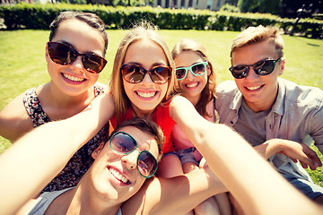 Image showing group of smiling friends making selfie in park