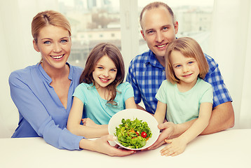 Image showing happy family with two kids with salad at home