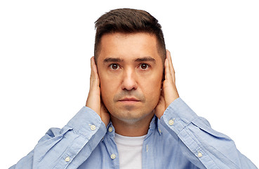 Image showing face of man covering his ears with hands