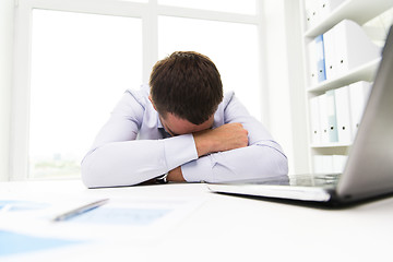 Image showing businessman with laptop and papers in office