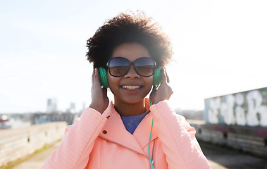 Image showing happy young woman in headphones listening to music