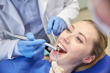 Image showing close up of dentist treating female patient teeth