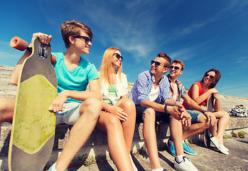 Image showing group of smiling friends sitting on city street