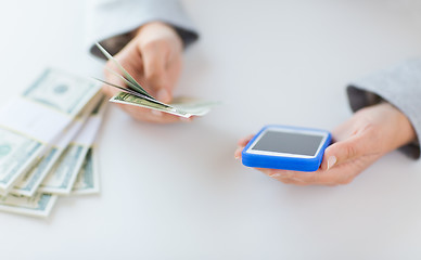 Image showing close up of woman hands with smartphone and money