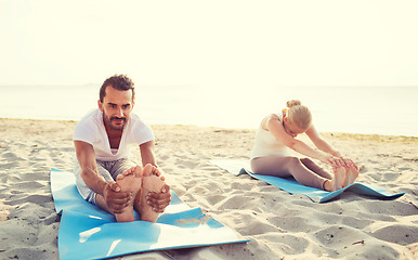 Image showing couple making yoga exercises outdoors