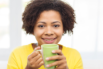 Image showing happy african american woman drinking from tea cup