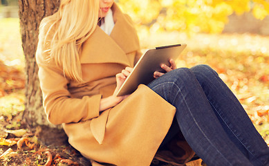 Image showing young woman with tablet pc in autumn park