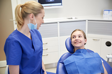 Image showing happy female dentist with patient girl at clinic